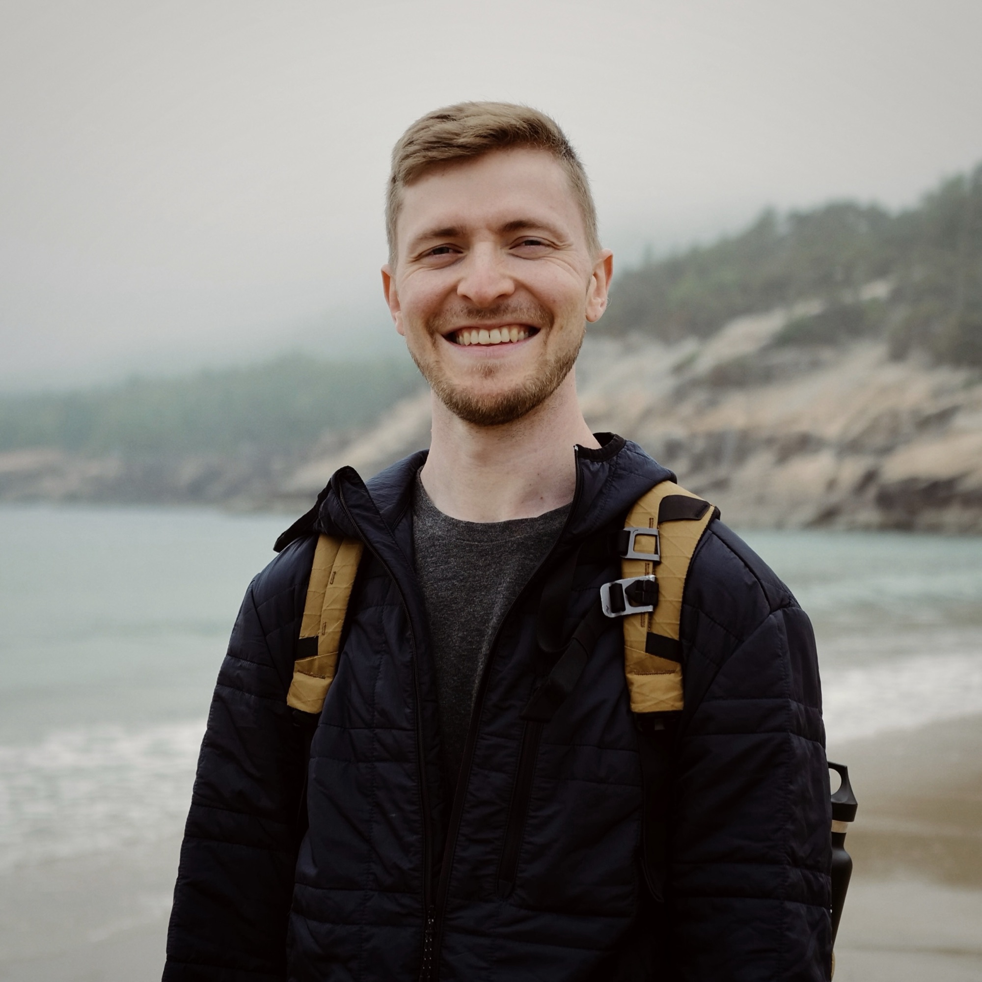 Ryan Sanderson smiling on a beach